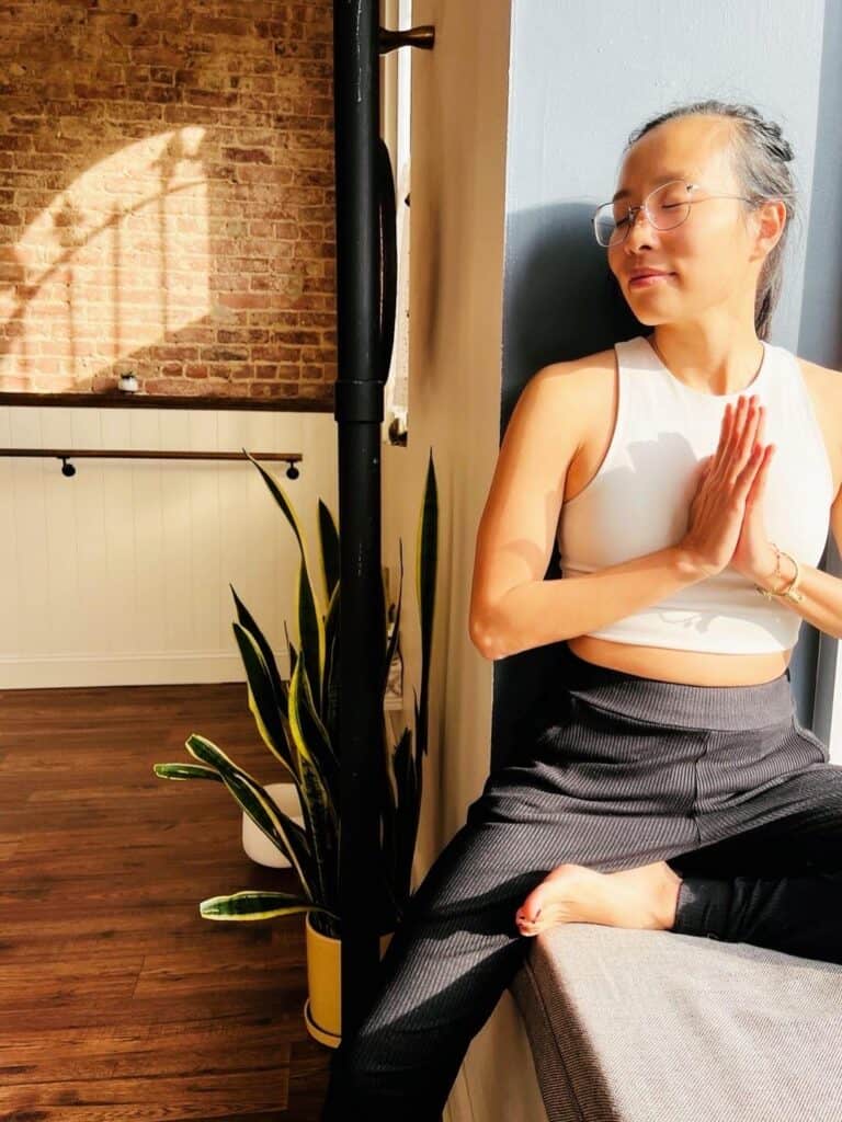 Inner peace yoga pose with woman meditating at Bedstuy Yoga studio.