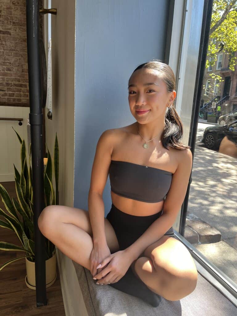 Relaxed yoga student sitting by the sunny window at Bedstuy Yoga studio in Brooklyn.