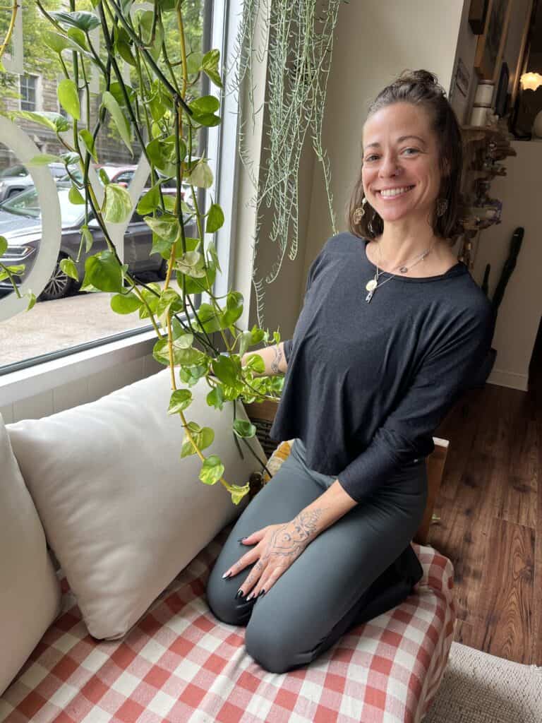 Lush green houseplant near person practicing yoga at Bedstuy Yoga studio.