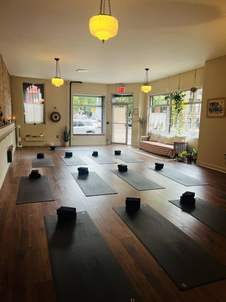 Serene yoga studio with mats prepared for class, natural light, and cozy décor in Bedstuy Yoga Brooklyn.