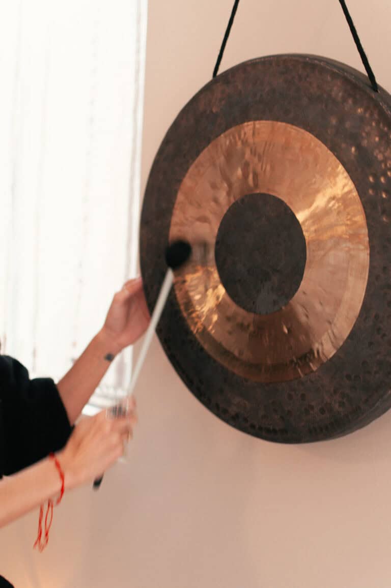 Gong being struck during a yoga or meditation class at Bedstuy Yoga.