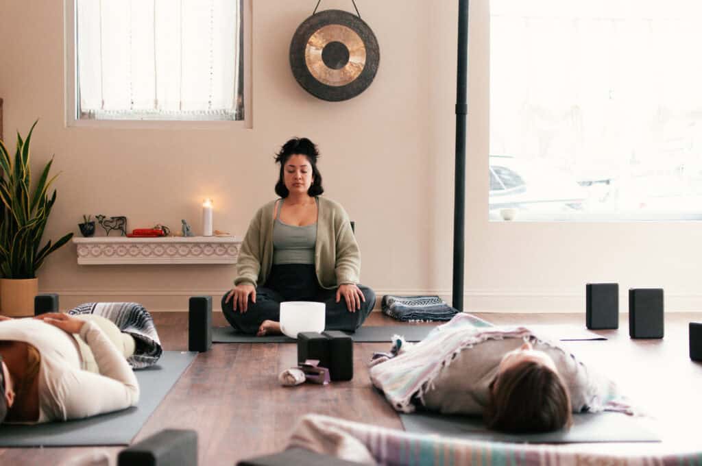 Calming Bedstuy yoga studio with women practicing meditation and mindfulness.