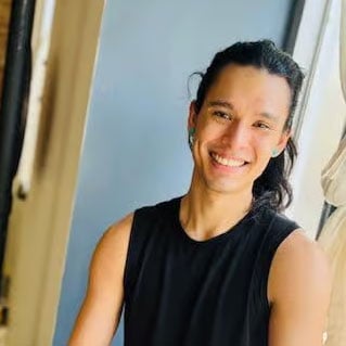 Yoga instructor smiling in a bright studio at Bedstuy Yoga.